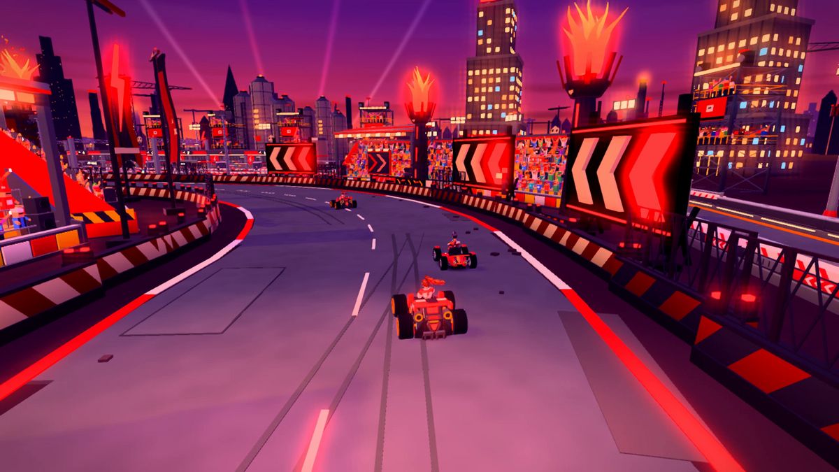 Karts rounding the final arena corner past packed grandstands, glowing chevrons and flame towers.